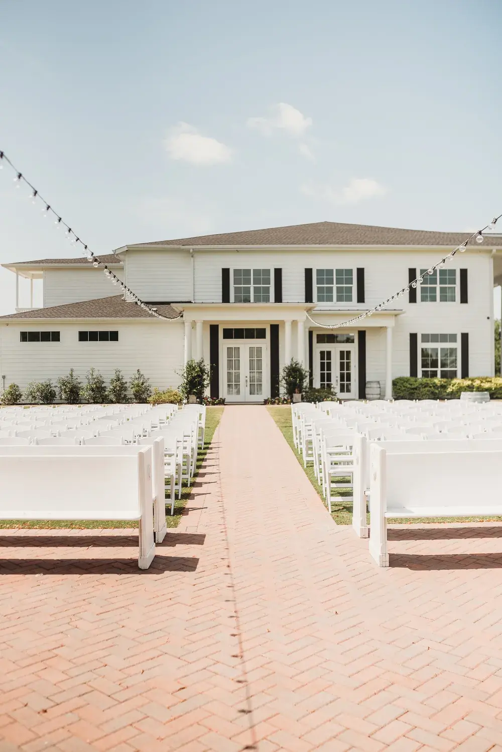 Outdoor ceremony chairs and brick aisle facing the mansion